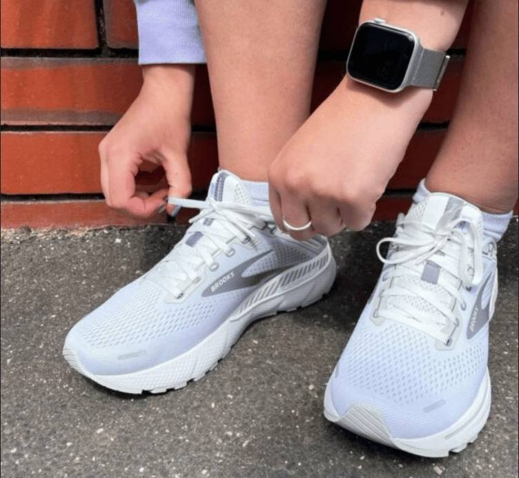 A close-up of the legs of a man running in the Adrenaline GTS 22 with illustrations of white rectangles beside the shoes.